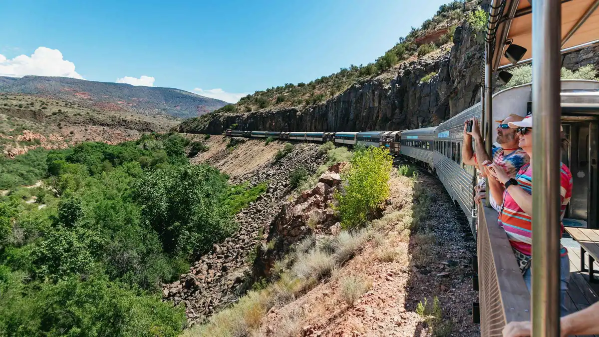 Vintage train winding through red rock canyon walls on the Verde Canyon Railroad